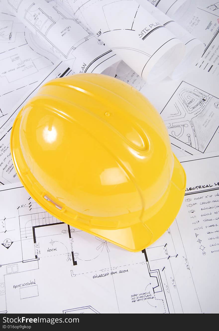 Building plans and yellow hardhat. Building plans and yellow hardhat