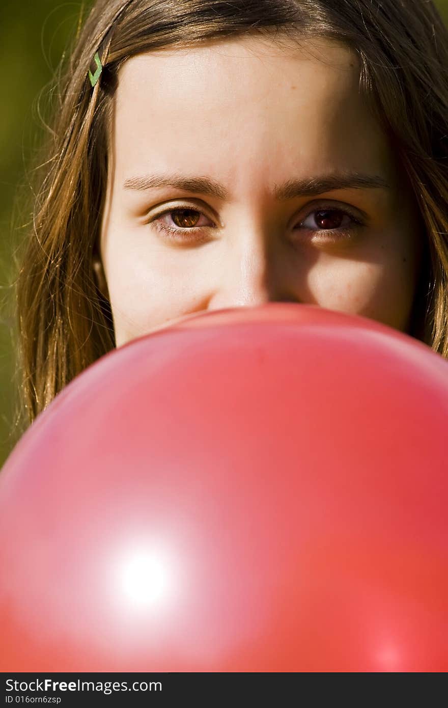 Young woman inflating red balloon