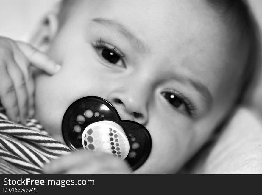 Beautiful baby sucking on his binky. Beautiful baby sucking on his binky