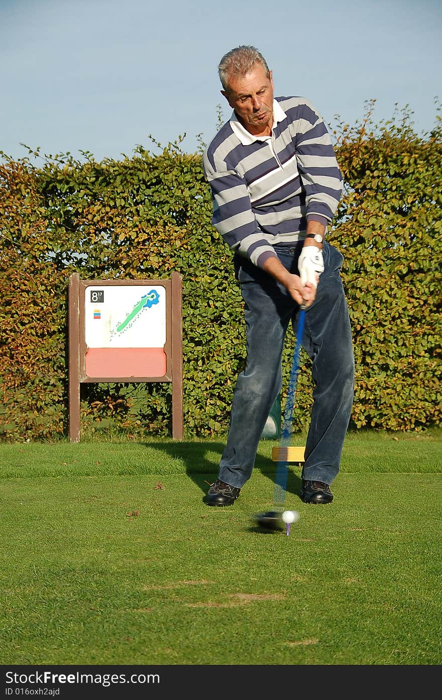 Male golfer teeing off