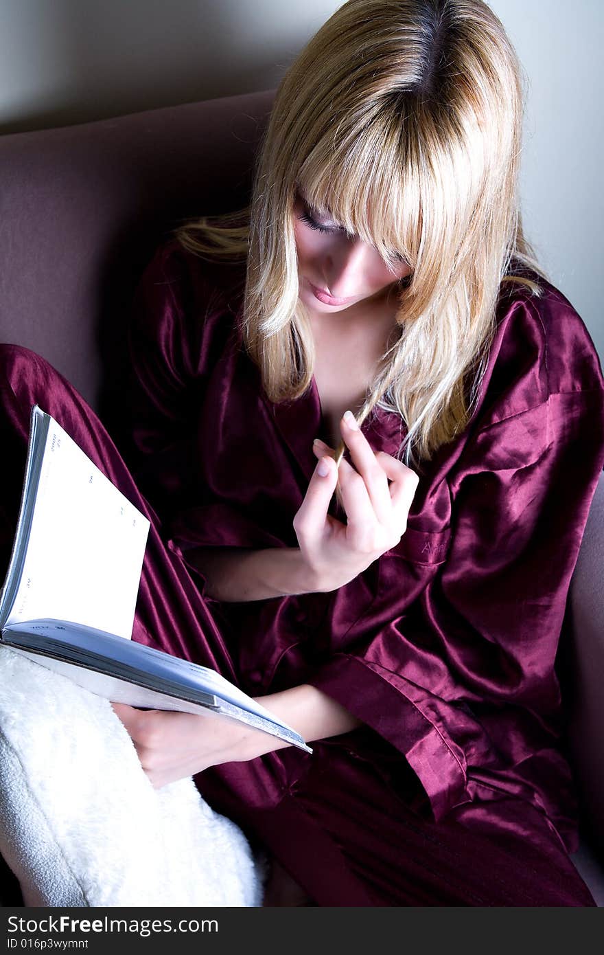 beautiful girl  is playing her hair while reading a book. beautiful girl  is playing her hair while reading a book