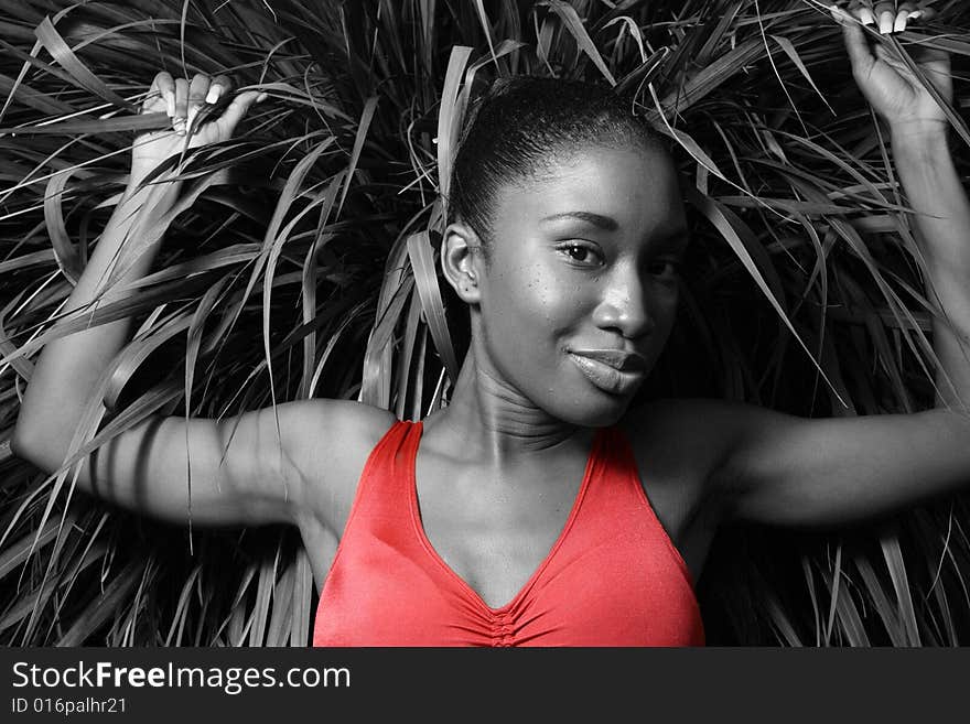 Young female holding on to tall blades of grass behind her. Only the shirt has color. Young female holding on to tall blades of grass behind her. Only the shirt has color.