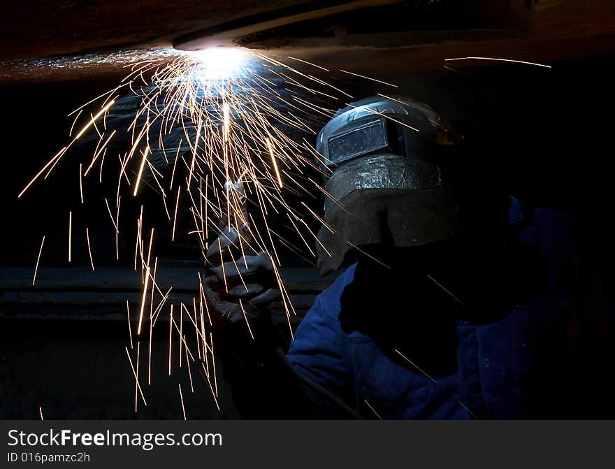 A welder working at shipyard at night. A welder working at shipyard at night