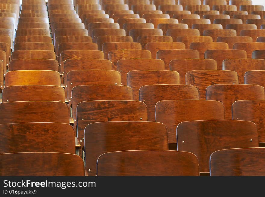 Rows of wood chairs in an old auditorium