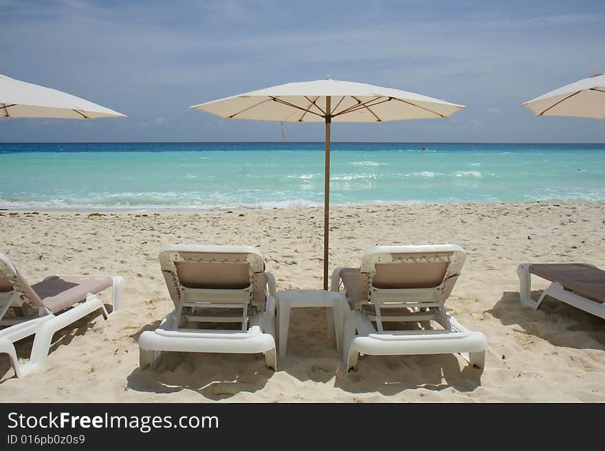 Beach view with lounge chairs and umbrella