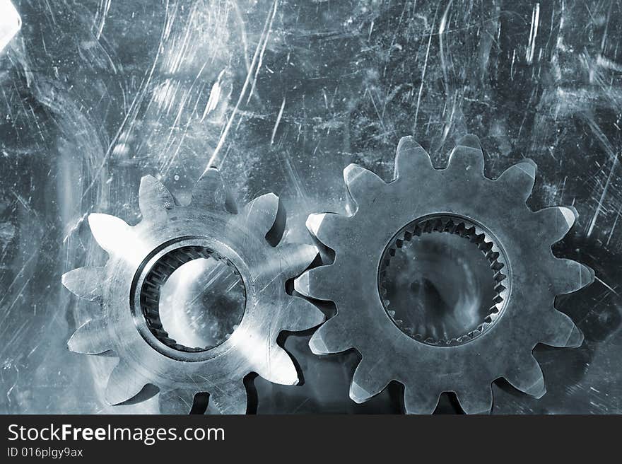 Large gears shot against scratched aluminum background and in a bluish toning idea. Large gears shot against scratched aluminum background and in a bluish toning idea.