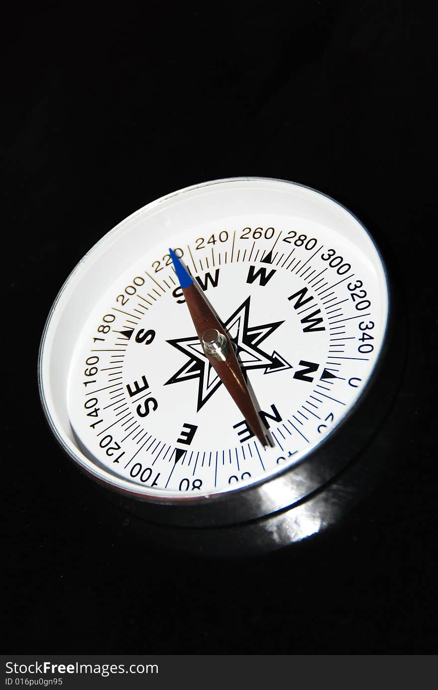 Still life of compass on black background.