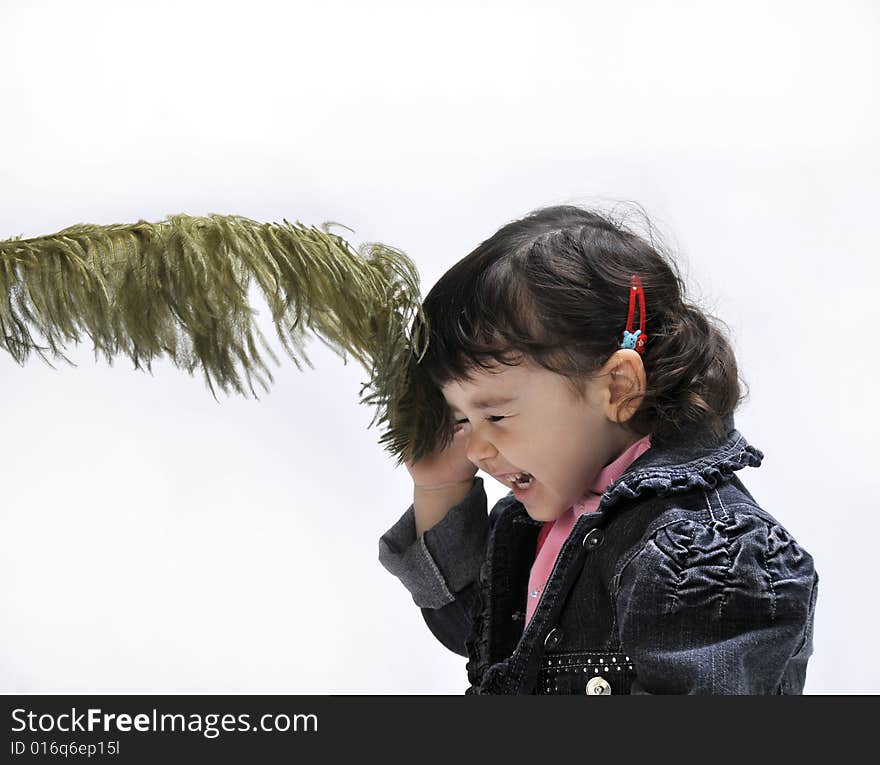 Portrait of little girl which is played with a feather