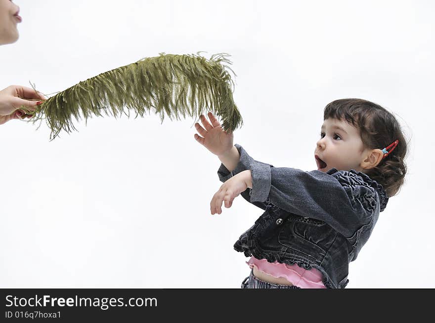 Portrait of little girl which is played with a feather