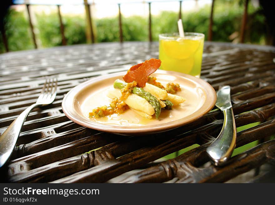 White and green asparagus starter served with bacon