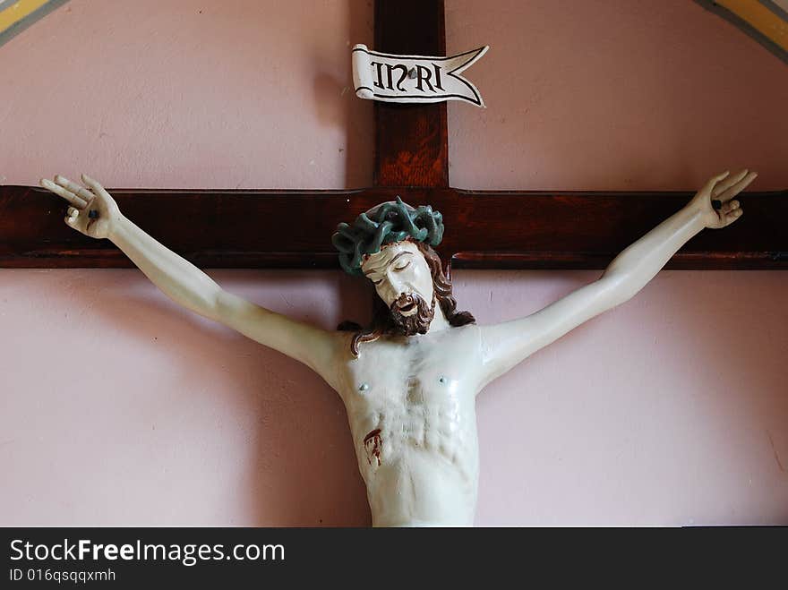 Jesus of Nazaret on cross. Figure  in church St. Bartolomeo - village Szyszki, state mazowieckie, Poland. The church of St. Bartolomeo is a historic cathedral constructed in 15th century, reconstructed in 1877-1899 years. It is the church of the Roman Catholic Diocese Płock. Jesus of Nazaret on cross. Figure  in church St. Bartolomeo - village Szyszki, state mazowieckie, Poland. The church of St. Bartolomeo is a historic cathedral constructed in 15th century, reconstructed in 1877-1899 years. It is the church of the Roman Catholic Diocese Płock.