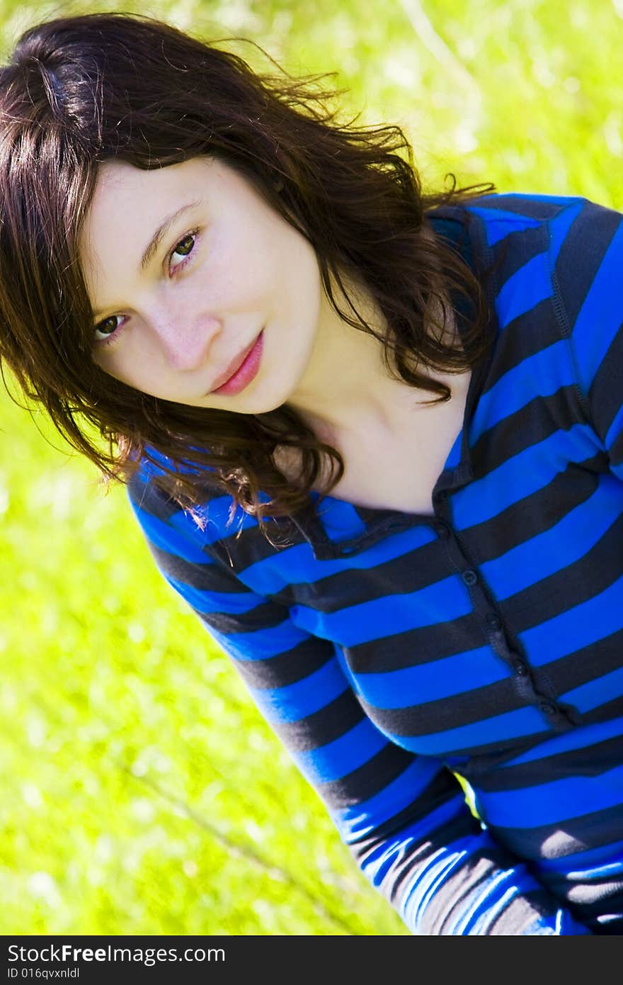 Smiling young girl staring at camera over green background. Smiling young girl staring at camera over green background