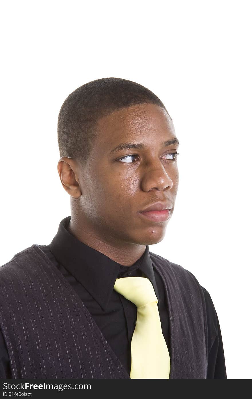 A young black man in a black shirt and sweater on white background wearing a yellow tie, looking to the right. A young black man in a black shirt and sweater on white background wearing a yellow tie, looking to the right