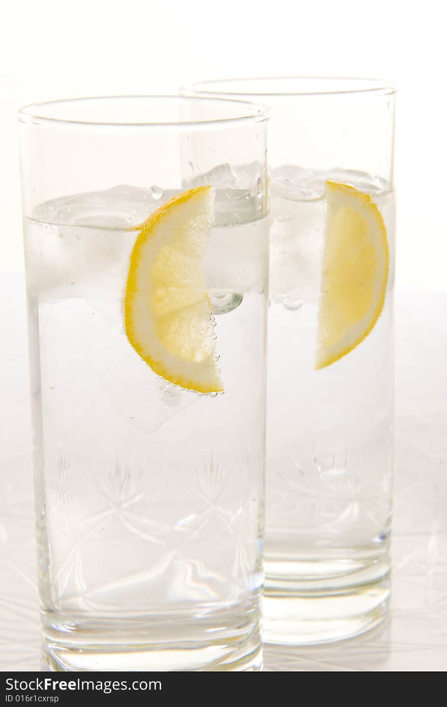 Sparkling water with slices of fresh lemon and lime on a white background. Sparkling water with slices of fresh lemon and lime on a white background.