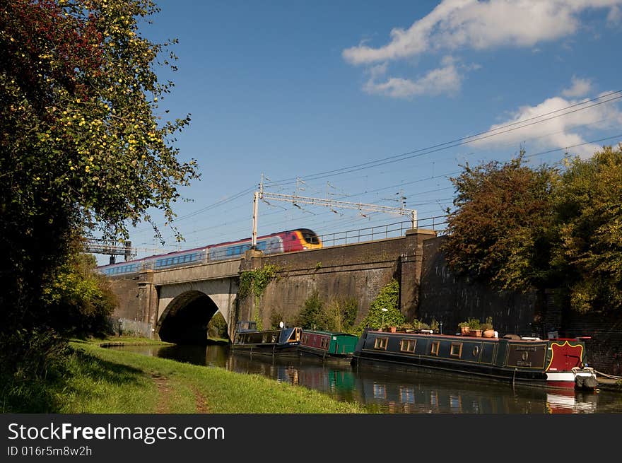 An intercity train crosses a bridge over a canal barge. An intercity train crosses a bridge over a canal barge