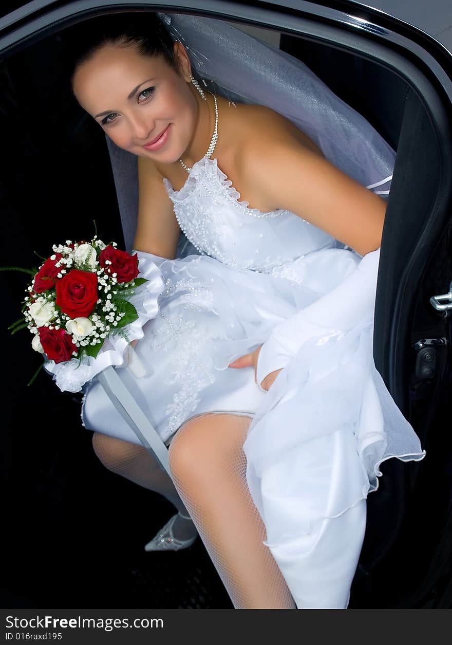 Portrait of the smiling bride in the car