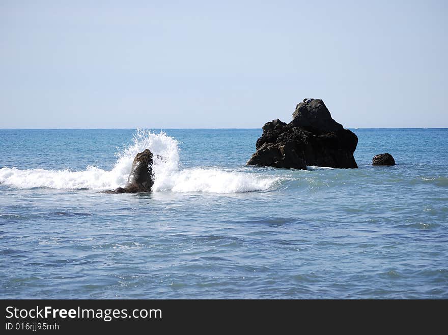 Rocks in the ocean with waves crashing