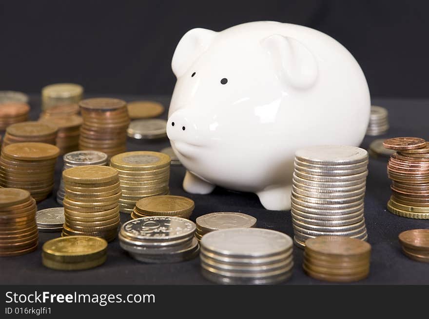 Piggy bank with various international currencies on a black background. Piggy bank with various international currencies on a black background.