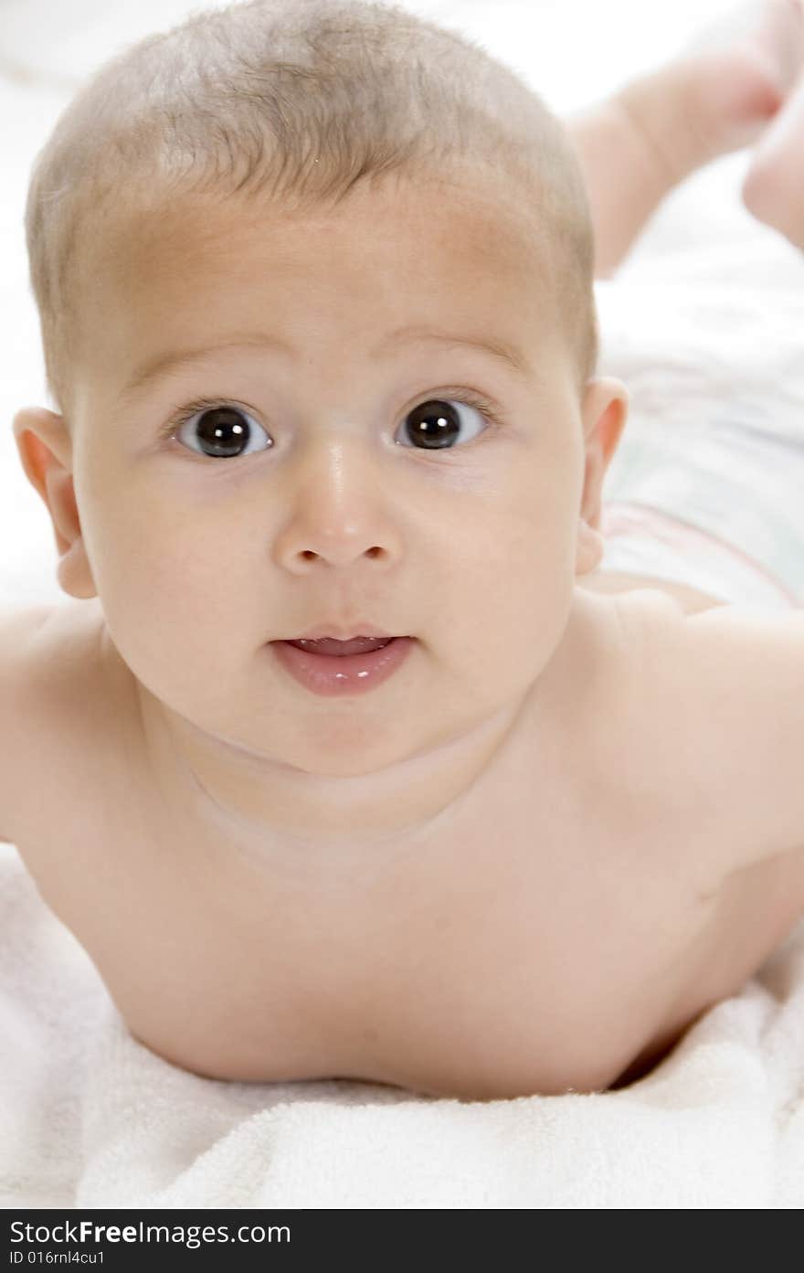 Happy child lying and looking at camera on an isolated white background