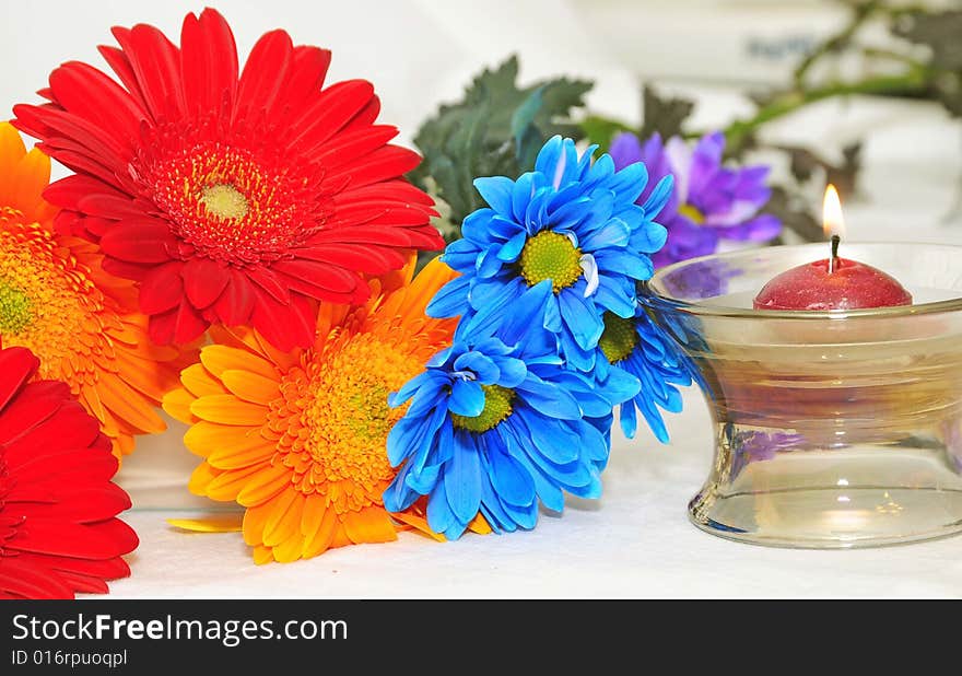 A colorful bunch of flowers and candle. A colorful bunch of flowers and candle