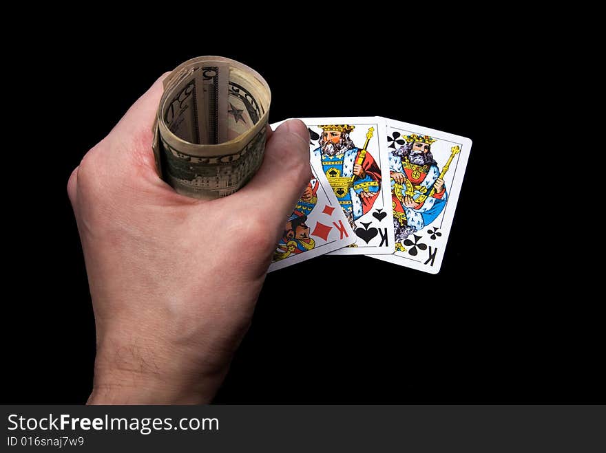 Playing cards and money in hand on black background