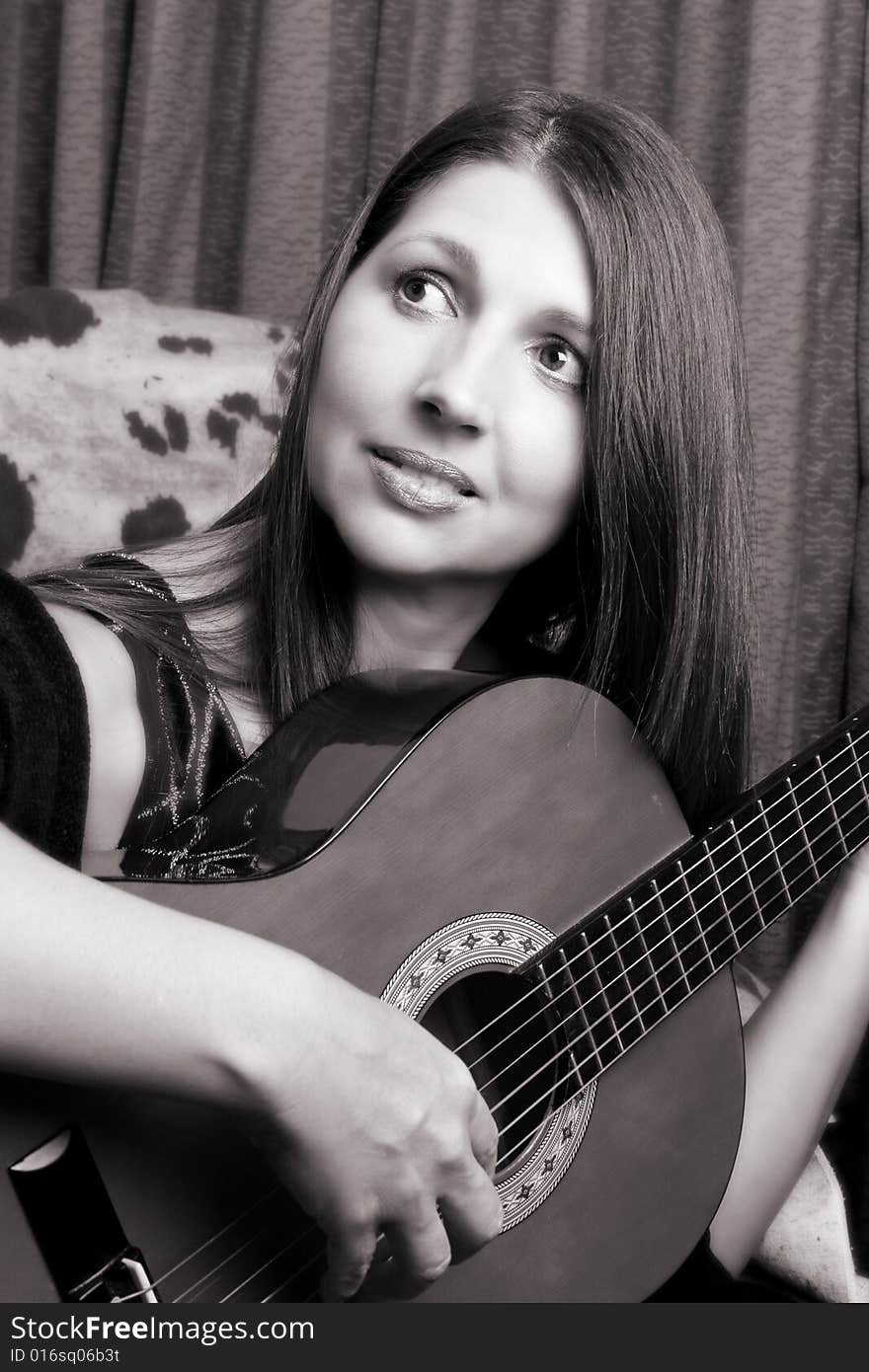 Mature brunette, playing guitar in her house. Mature brunette, playing guitar in her house