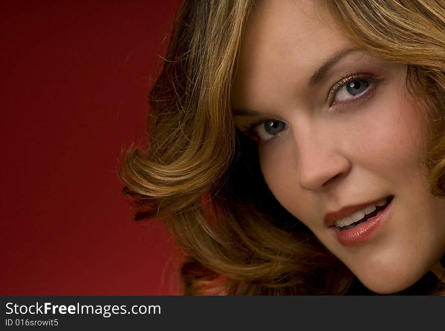 Close-up of beautiful woman on Christmas red background watching towards the camera. Close-up of beautiful woman on Christmas red background watching towards the camera