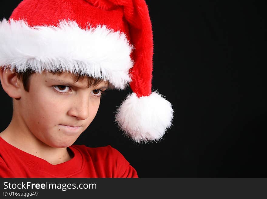 Young boy wearing a red shirt and christmas hat. Young boy wearing a red shirt and christmas hat