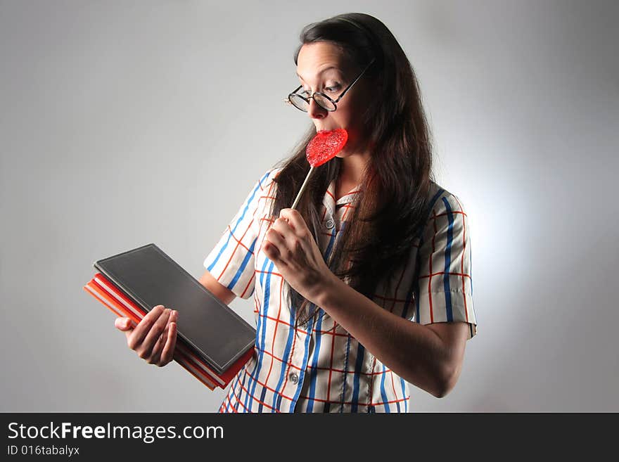 Young student with books and lollipop. Young student with books and lollipop