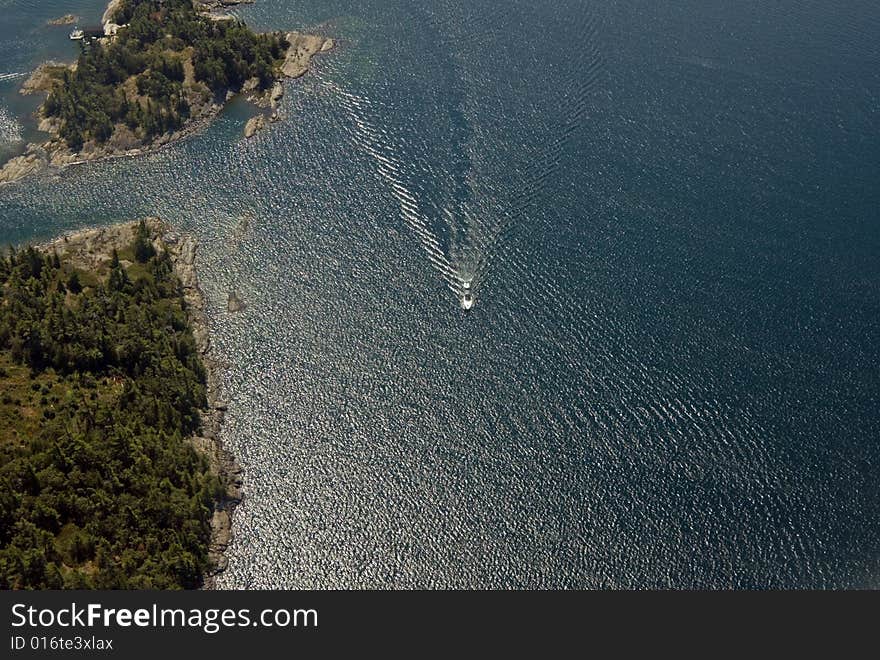 Small boat tracks on surface of water in sunlit