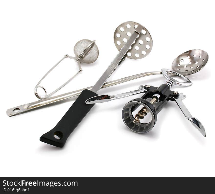 Two perforated spoons, tea strainer and corkscrew isolated on a white background