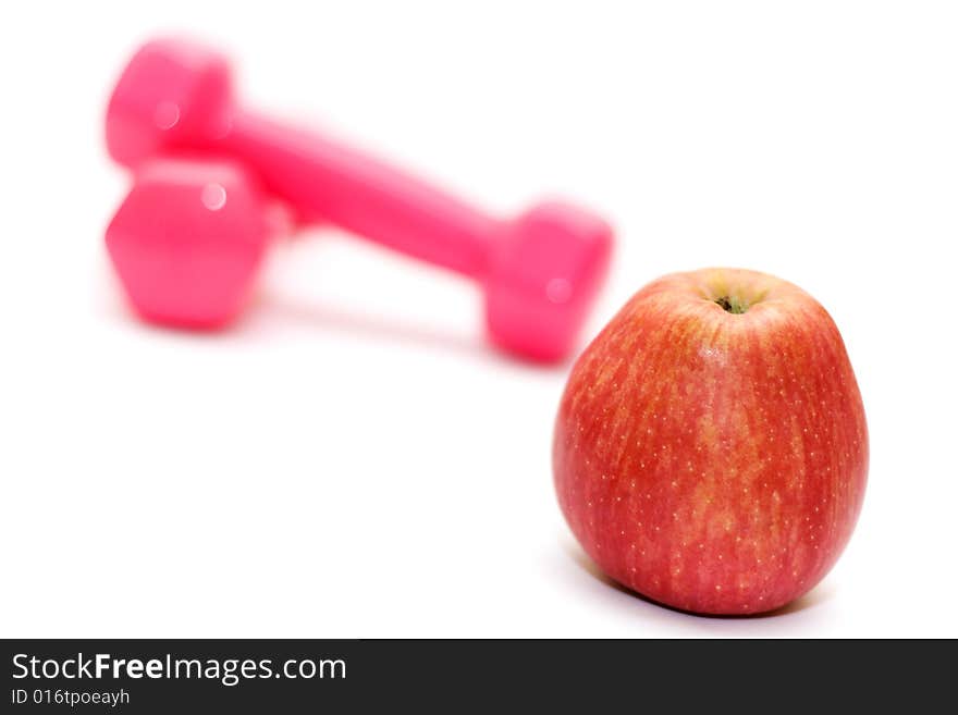 Dumbbells and apple on the white(shallow DOF,focus on apple). Dumbbells and apple on the white(shallow DOF,focus on apple)