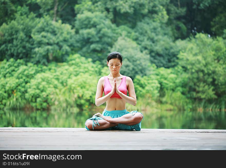 A young chinese woman practicing yoga in the outdoors. A young chinese woman practicing yoga in the outdoors