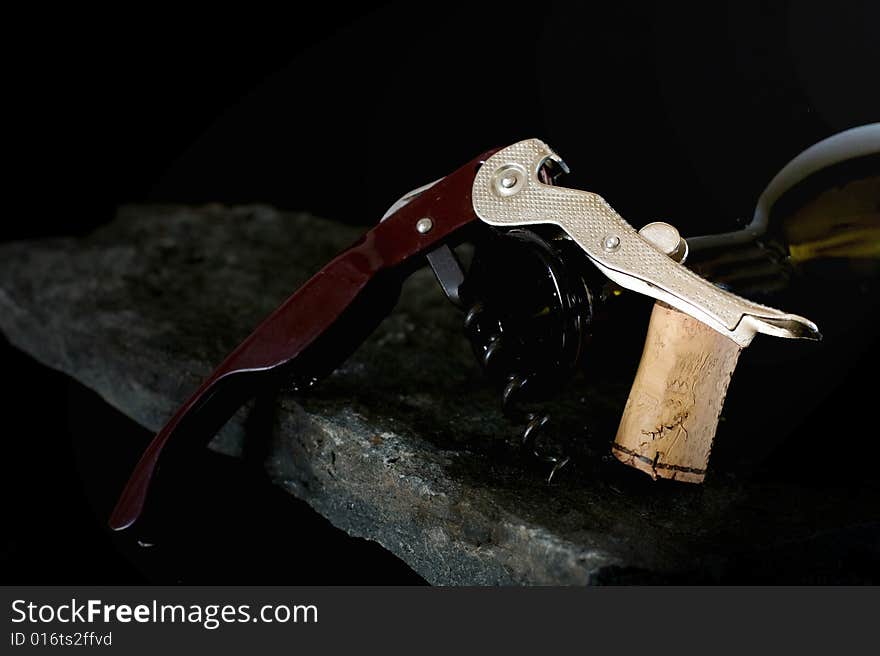 Corkscrew for opening wine bottles on black background