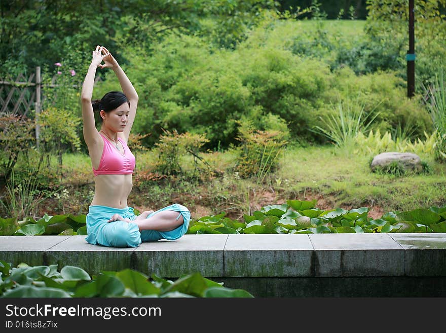 Young chinese woman practicing yoga outdoor