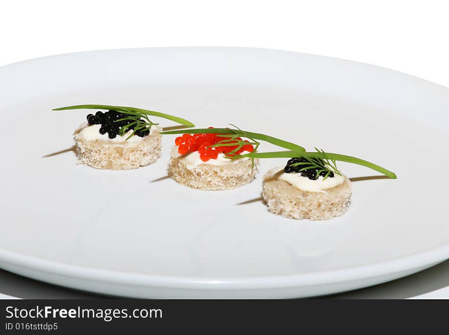 Black and red caviar on plate with onion and dill