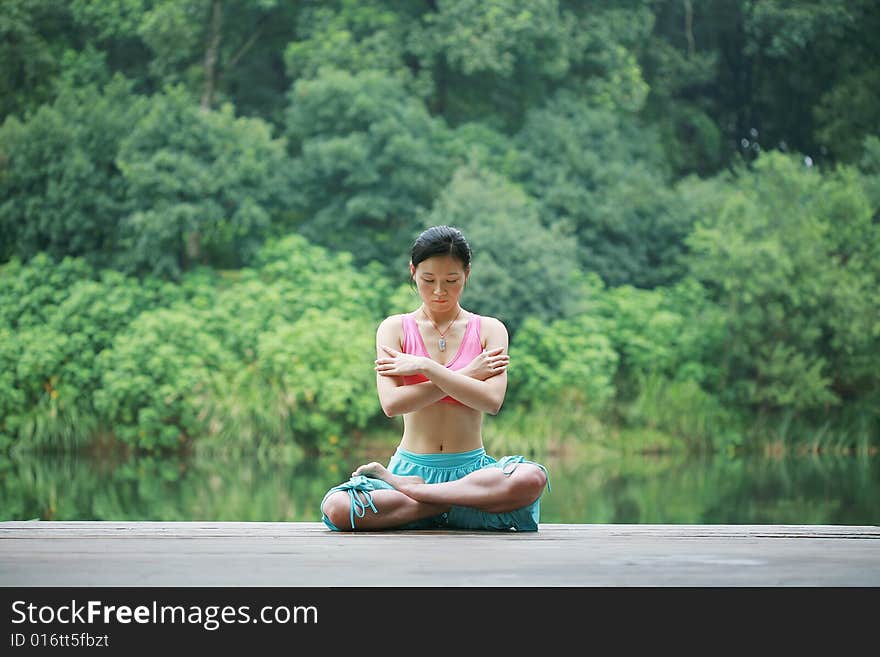 Young chinese woman practicing yoga outdoor