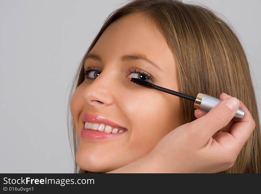 Pretty woman applying make up.