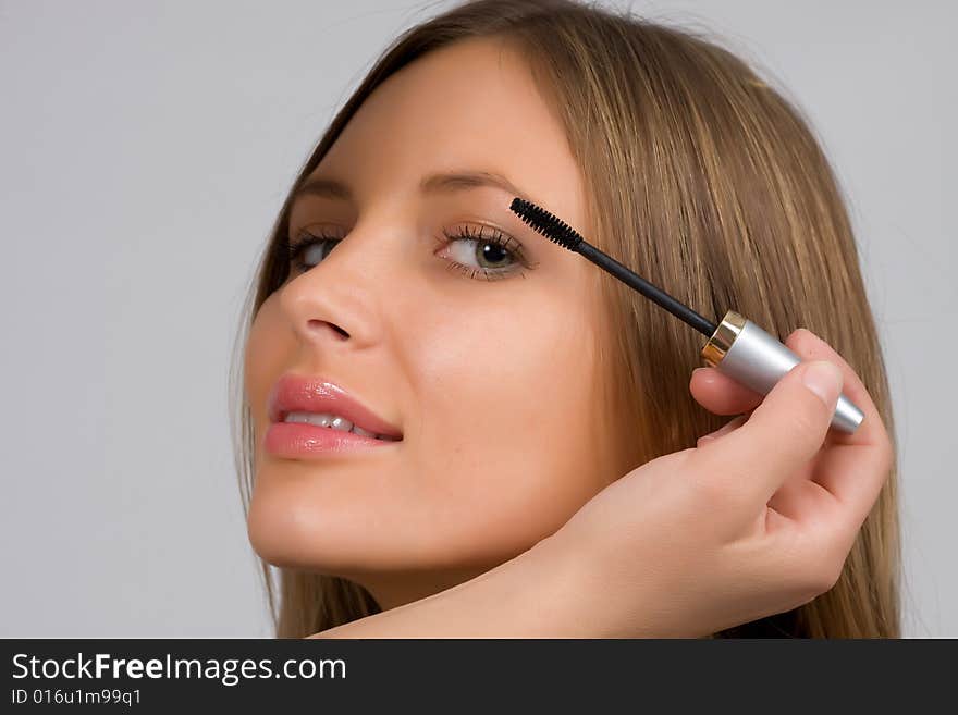 Pretty woman applying make up.