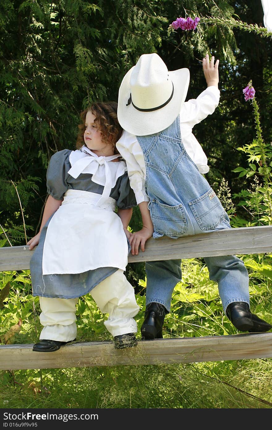 Young boy picking flowers for a young girl. Young boy picking flowers for a young girl