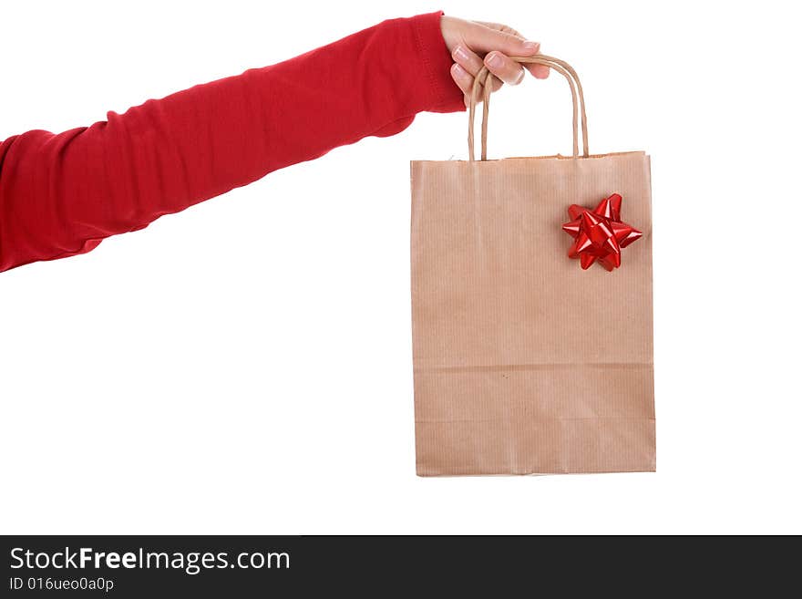 Woman hand holding papper bag with red ribbon isolated on white background