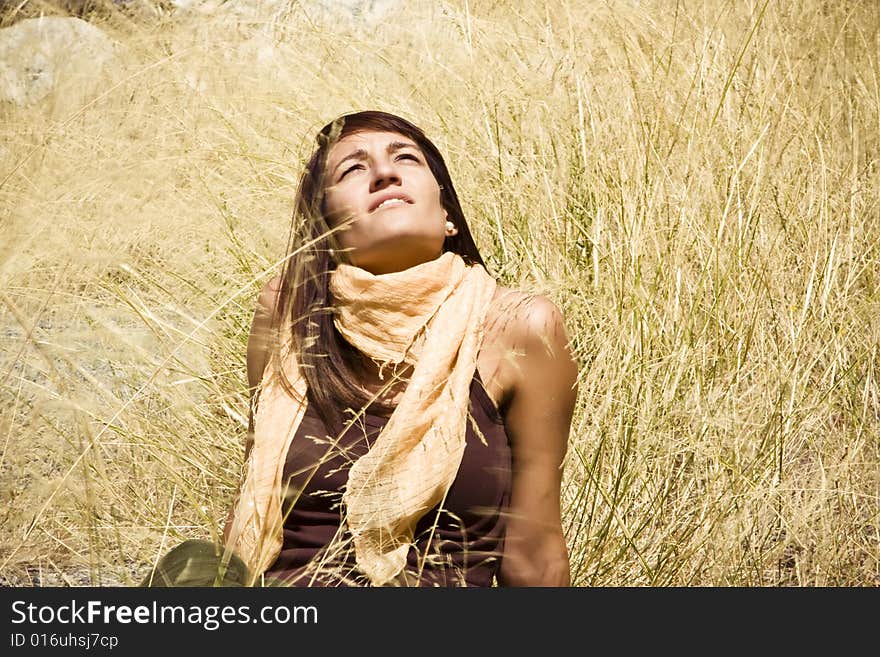 Young woman staring at the sun in the middle of a field. Young woman staring at the sun in the middle of a field.