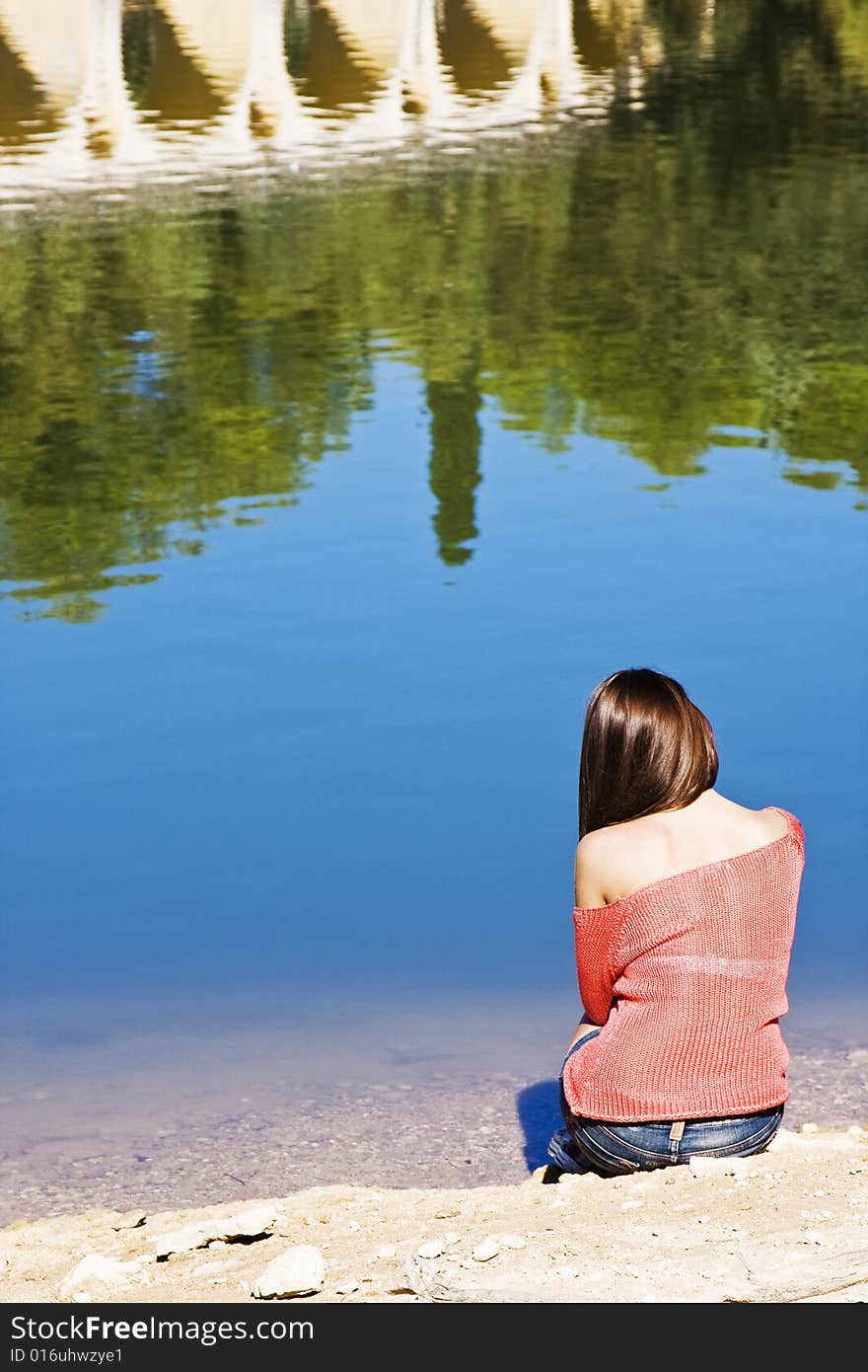 Thoughtful woman sitting in lake shore. Thoughtful woman sitting in lake shore.