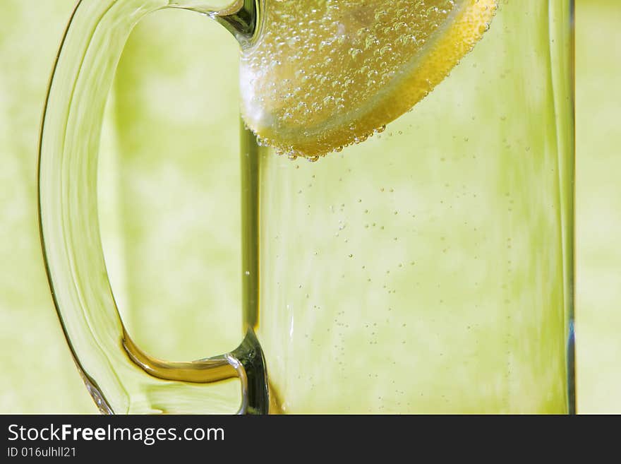 Lemon slice floating in a transparent glass full with sparkling water (club soda). Lemon slice floating in a transparent glass full with sparkling water (club soda)