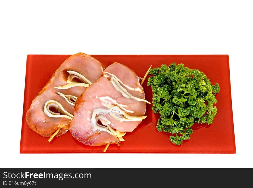 Tenderloin with ham and cheese on red plate, white background, studio shot,