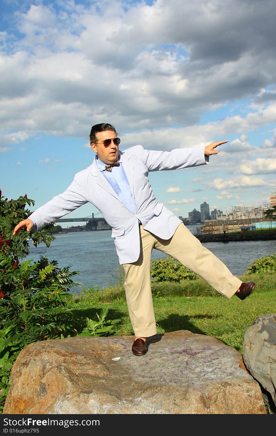 Casually dressed man balancing on a rock. Casually dressed man balancing on a rock