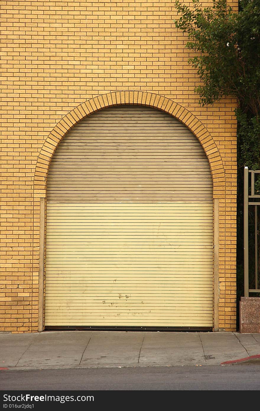 Arched rolling garage door with brick wall