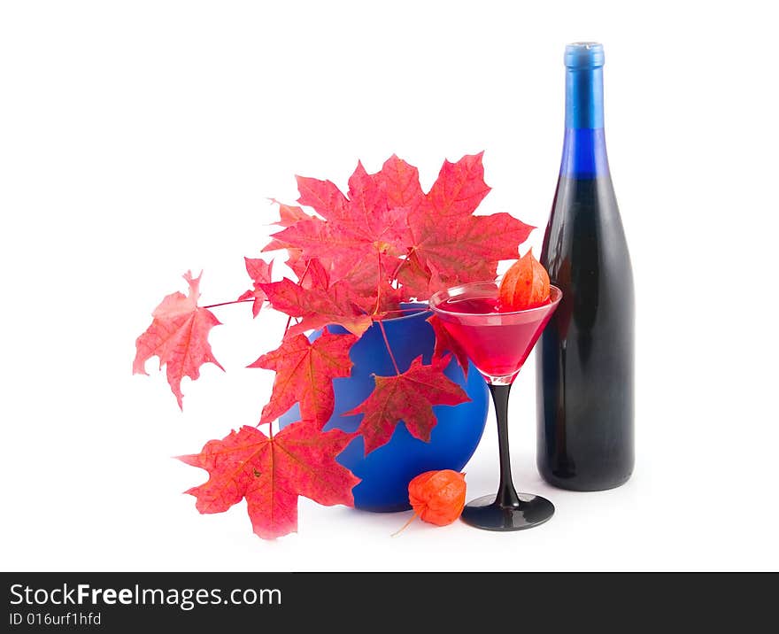 Red maple on white background with wine in wine glass