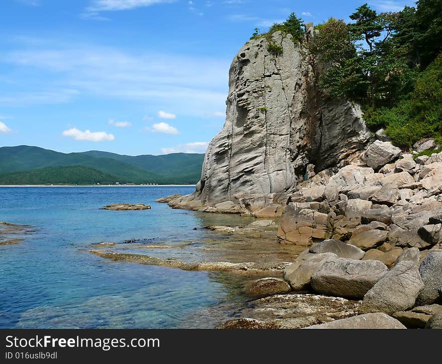 A very small bay among fancy rocks. Seacoast of Petrova island - pearl of nature state reserve Lazovsky. Russian Far East, Primorye. A very small bay among fancy rocks. Seacoast of Petrova island - pearl of nature state reserve Lazovsky. Russian Far East, Primorye.