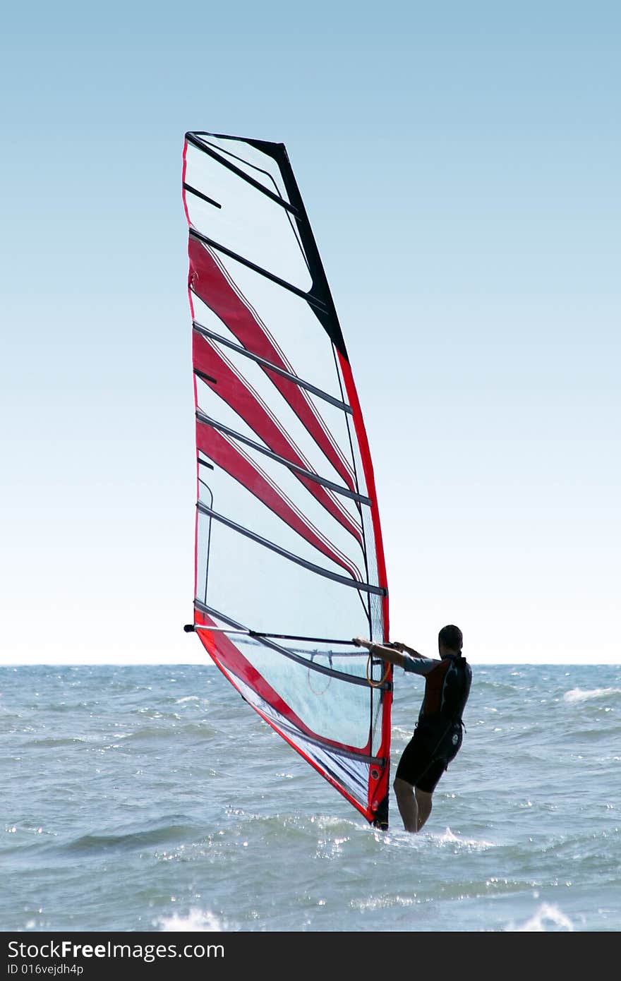 Silhouette of a windsurfer on waves of a sea 2